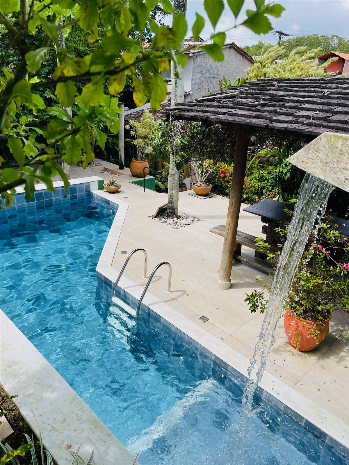 Piscina com cascata e quiosque do hotel