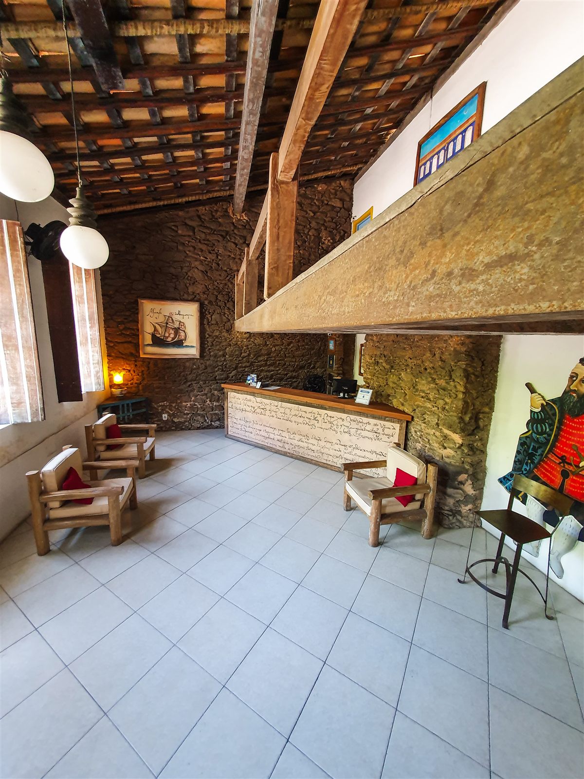 Recepção do hotel com teto de madeira e paredes de pedra